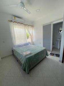 a bedroom with a bed and a window and a sink at Hotel Casa Colonial Moñitos in Moñitos