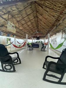 a group of black chairs in a room with a ceiling at Hotel Casa Colonial Moñitos in Moñitos