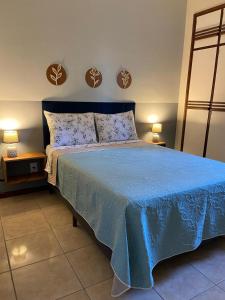 AP bem localizado na Praia do Canto في فيتوريا: غرفة نوم بسرير ازرق وعليها مصباحين