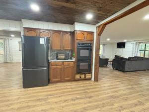 una cucina con frigorifero nero e un soggiorno di Blindfrog a Scottsboro