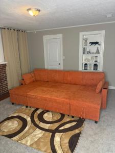 8mins from Jaguar stadium & the Historical Riverside في جاكسونفيل: أريكة بنية في غرفة المعيشة