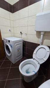 a bathroom with a toilet with a washing machine at Apartman Mimi in Bratunac