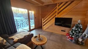 a living room with a christmas tree and a television at Domki góralskie Sabałecka in Zakopane