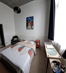 una habitación de hotel con dos camas y una mesa en Le Piercot, en Lieja