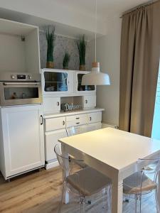 a kitchen with white cabinets and a table and chairs at BoLA Ferienwohnung Hamburg 52 ruhig 2 Personen in Hamburg