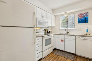 a kitchen with white cabinets and a refrigerator at 3C Amelia Landings Condo in Fernandina Beach