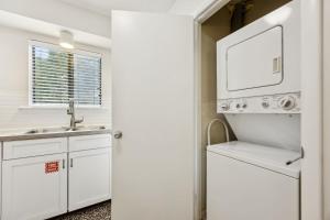 a white kitchen with a sink and a washer and dryer at 3C Amelia Landings Condo in Fernandina Beach