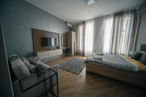 a bedroom with a bed and a television in a room at Ivi Central Apartments in Novi Sad