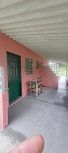 Hostel33 brazil praia في كاراغواتاتوبا: شخص يشير إلى مبنى به طاولة وباب أخضر