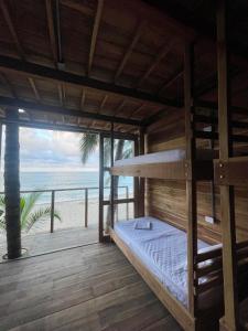 a bed in a room with a view of the beach at Calma Chicha in Santa Marta