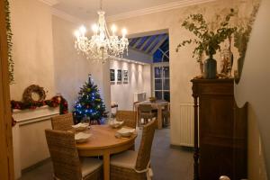 a dining room with a christmas tree and a table at Maison Rose in Ieper