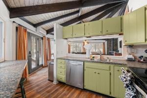 a kitchen with green cabinets and a wooden floor at Chic 2 BD 2 BA Near Skiing Fireplace etc in Pocono Pines