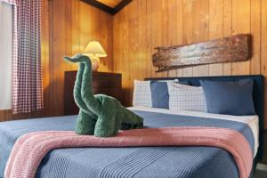 a toy dinosaur sitting on top of a bed at Chic 2 BD 2 BA Near Skiing Fireplace etc in Pocono Pines