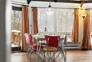 a dining room with a table and red chairs at Chic 2 BD 2 BA Near Skiing Fireplace etc in Pocono Pines
