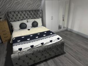un dormitorio con una cama grande con almohadas blancas y negras en Guest Home, en Birmingham