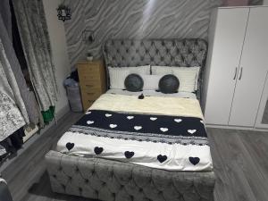 1 dormitorio con 1 cama grande con sábanas blancas y negras en Guest Home, en Birmingham