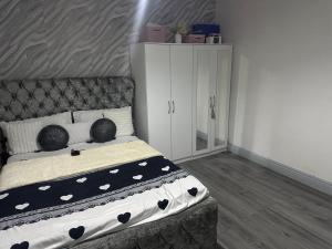 Un dormitorio con una cama con almohadas blancas y negras. en Guest Home, en Birmingham