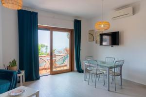 a dining room with a table and chairs and a balcony at A Me Casa - Taormina in Taormina +19 photos