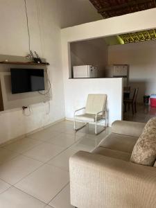 a living room with a couch and a tv at Casa em Porto de pedras in Tatuamunha