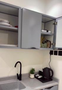 a kitchen counter with a sink and a microwave at شقة استديو- السليمانية in Riyadh