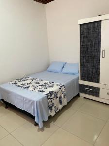a bedroom with a bed with blue and white sheets at Casa em Porto de pedras in Tatuamunha
