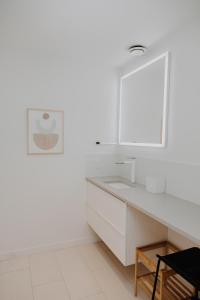 a white bathroom with a sink and a mirror at Luxury 1BR at Red Mountain Ski-Bike Sauna in Rossland +25 photos