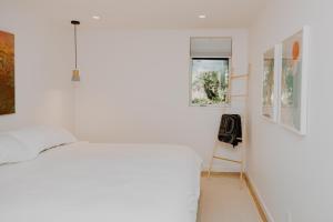 a white room with a bed and paintings on the wall at Luxury 1BR at Red Mountain Ski-Bike Sauna in Rossland