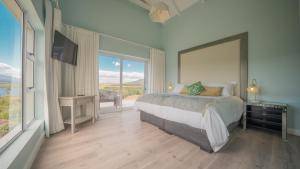 a bedroom with a large bed and a large window at Swallows Rest - Benguela Cove in Hermanus +65 photos