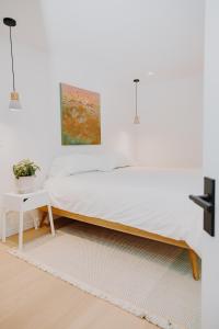 a white bedroom with a bed and a table at Luxury 1BR at Red Mountain Ski-Bike Sauna in Rossland