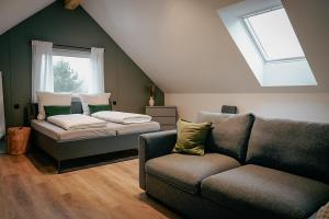 een woonkamer met een bank en een bed bij Traumnest Eifel mit Sauna & Whirlpool in Monschau +30 foto's