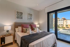 Un dormitorio con una cama grande y un balcón. en Los Flamencos Isla Canela I, en Isla Canela 27 fotos más