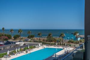 Una vista de la piscina y la playa desde el balcón de un resort. en Los Flamencos Isla Canela I, en Isla Canela