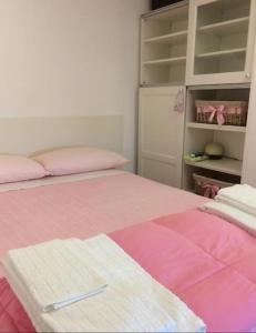 a bedroom with two beds with pink and pink sheets at La Roseraie in Battipaglia