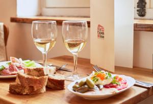 two glasses of white wine and a plate of food at La Roseraie in Battipaglia