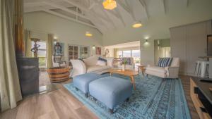 een woonkamer met een bank en een tafel bij Swallows Rest - Benguela Cove in Hermanus