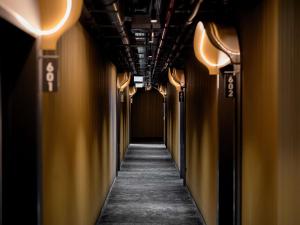 een gang van een gang met gele muren en lichten bij You Hotel Budapest - Handwritten Collection in Boedapest