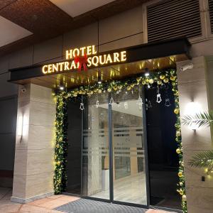 a hotel entrance with a hotel central square sign and lights at Central Square Hotel in Baku