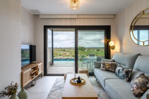 Una sala de estar con un sofá y un televisor. en Los Flamencos Isla Canela 2, en Isla Canela