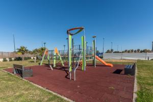 un parque infantil con un tobogán naranja y verde en Los Flamencos Isla Canela 2, en Isla Canela