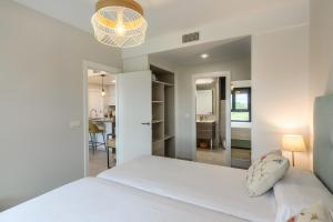 Un dormitorio con una cama blanca y un comedor. en Los Flamencos Isla Canela 2, en Isla Canela 23 fotos más