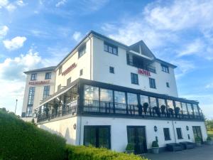 波莫洛赫博莫尔罗克酒店的一座白色的建筑,人们坐在阳台上