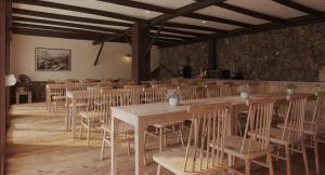Habitación con mesas de madera y sillas en un edificio en My Rooms Hostel Las Salas by My Rooms Hotels - Albergue, en Las Salas