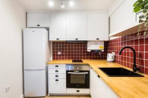 a kitchen with white cabinets and a refrigerator at Casa da Se Cottage in Silves