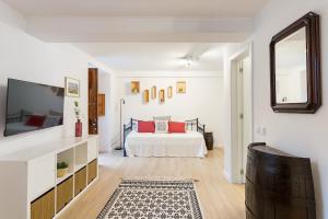 a white bedroom with a bed and a tv at Casa da Se Cottage in Silves