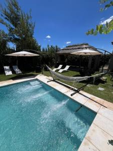 a swimming pool with two chairs and an umbrella at Departamentos Merceditas in San Rafael +54 photos