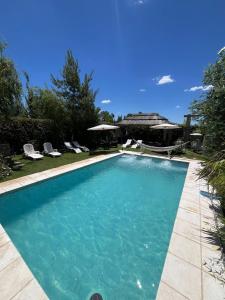 a swimming pool with blue water in a yard at Departamentos Merceditas in San Rafael