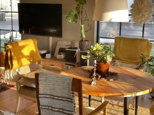 a living room with a wooden table and a tv at Villa Golfgatan 32 Vintrosa Lanna in Vintrosa