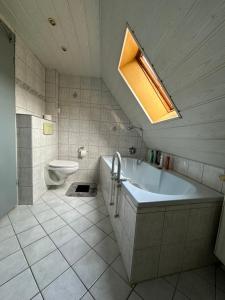 a bathroom with a tub and a toilet and a sink at Corner Haus Large Room in Schnaittach