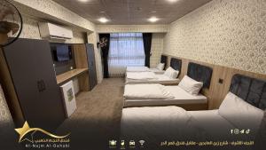 纳杰夫Hotel golden star的一间设有四张床和电视的房间