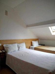 a hotel room with two beds and a window at Internacional in Coimbra